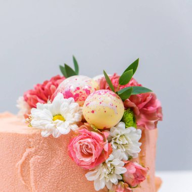 Beyaz ahşap arka planda siyah tepsi üzerinde kalan şık renkli kek Dekoratif unsurları. Doğum günü partisi kutlama hediyesi.