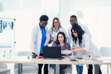 Çok ulusal doktor analiz konferans odasında tartışıldığı dizüstü kullanarak grup. Yan görünüm.