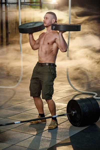 英俊的适合男子做运动与体重板在健身房. — 图库照片