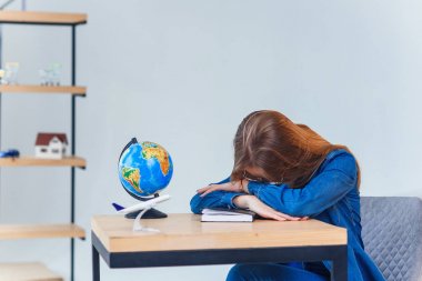 Yorgun genç kız sınav test hazırlıkları öğrenme uzun saatler sonra yorgun uykuya dalma. Üniversiteli kız öğrenci masada uyuyor.