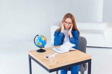 Genç kadın ofis çalışanı zor iş gününden sonra baş ağrısı var. Yorgunluk ve aşırı çalışan kız tapınaklar ellerini tutar.