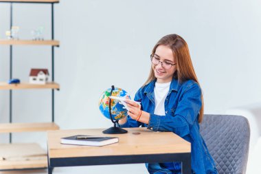 Tatilin hayalini kurangüzel bir kadın. Kız elinde uçak bir model tutar ve küçük bir dünya etrafında uçar.