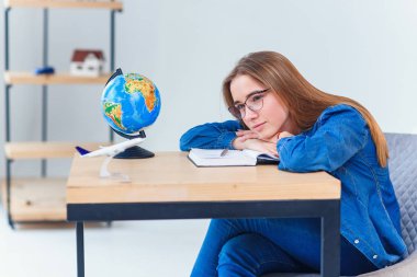 Yorgun genç kız sınav test hazırlıkları öğrenme uzun saatler sonra yorgun uykuya dalma. Üniversiteli kız öğrenci masada uyuyor.