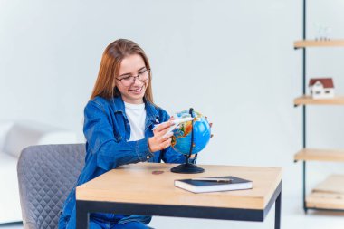 Genç gülümseyen kadın elinde uçak modeli tutar. Mutlu güzel kız tatil gezisi planlama.