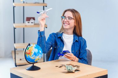 Dünyayı dolaşın. Komik yolculuk yolculuk keyfini çıkarın. Kız elinde uçak ve araba modelleri tutar.