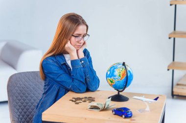 Üzgün kız, tasarruflarını ve seyahatler ve kendi araçları yla ilgili hayallerini sayar. Tasarruf parası kavramı.