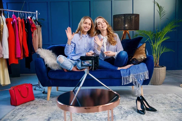 İki güzel genç kadın portre merhaba söyleyerek ve video blog kaydederken sallayarak.