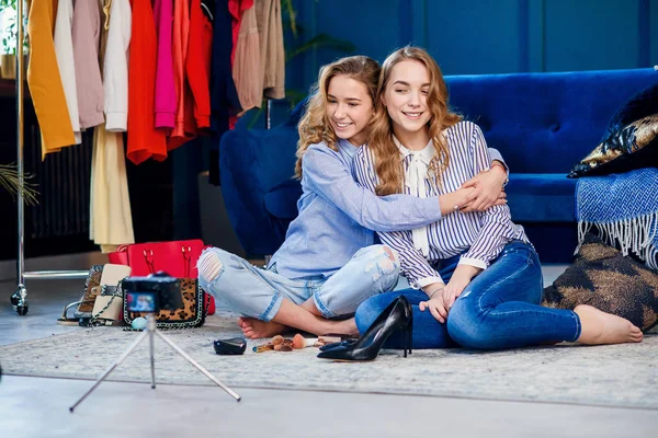 Dois bonitos blogueiros de moda abraçando no elegante escritório azul . — Fotografia de Stock