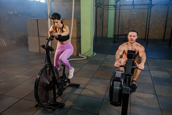 Kaukasische sport man en vrouw tijdens de training in de sportschool. — Stockfoto