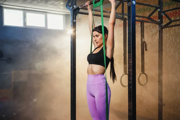 Joven deportista haciendo pull up en el gimnasio . — Foto de Stock