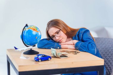 Üzgün kız, tasarruflarını ve seyahatler ve kendi araçları yla ilgili hayallerini sayar. Tasarruf parası kavramı.