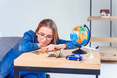 Üzgün kız, tasarruflarını ve seyahatler ve kendi araçları yla ilgili hayallerini sayar. Tasarruf parası kavramı.