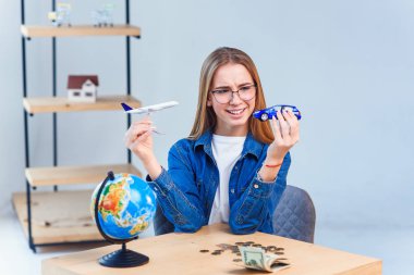 Kız elinde uçak ve araba modelleri tutar ve yolculuk için en iyi ulaşım seçerek. Renkli hayatınız için dünyayı dolaşın.