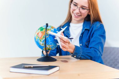 Genç gülümseyen kadın elinde uçak modeli tutar. Mutlu güzel kız tatil gezisi planlama.