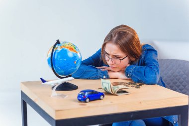 Üzgün kız, tasarruflarını ve seyahatler ve kendi araçları yla ilgili hayallerini sayar. Tasarruf parası kavramı.