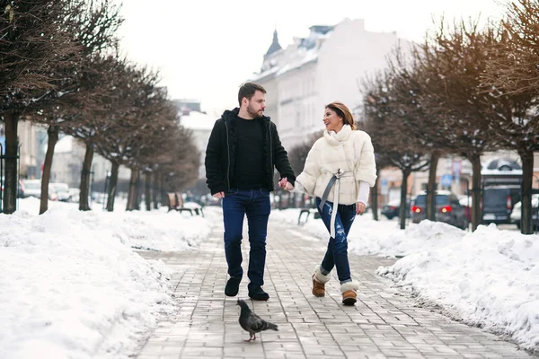 Güzel mutlu kız ve yakışıklı erkek arkadaşı kışın karlı caddede birlikte yürüyorlar. Yeni yıl ve Noel konsepti. — Stok fotoğraf