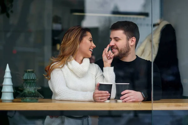 Ραντεβού σε ένα καφέ. Όμορφο χαμογελαστό κορίτσι με το αγόρι της να κάθεται σε ένα καφέ απολαμβάνοντας τον καφέ και τη συζήτηση. — Φωτογραφία Αρχείου