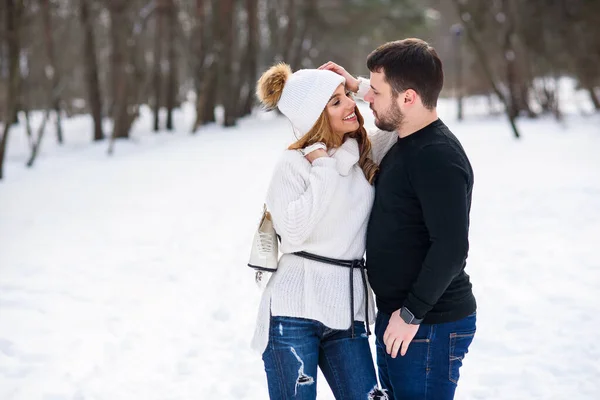 Beau couple amoureux s'embrasser tout en marchant dans un parc d'hiver . — Photo