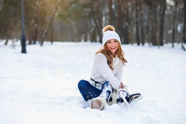 Mladá žena sedí na mrazivém sněhu v zimním parku. Koncept zimních prázdnin. — Stock fotografie
