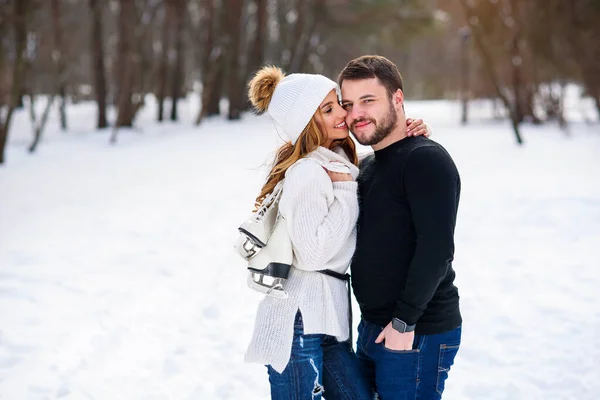 美丽的一对恋人在冬日的公园里散步时拥抱在一起. — 图库照片
