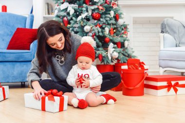 Annesiyle birlikte tatil hediyelerini açan sevimli bir çocuk..