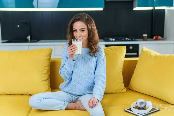 A mulher atraente segura um copo de leite fresco e bebe-o na elegante cozinha acolhedora pela manhã. Bebidas saudáveis . — Fotografia de Stock