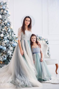 Güzel genç anne ile kızı yeni yıl iç Noel ağacı yakınındaki.