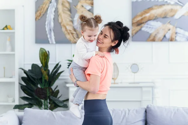 Jong mooi moeder hebben plezier met haar peuter dochter in gezellig huis. — Stockfoto