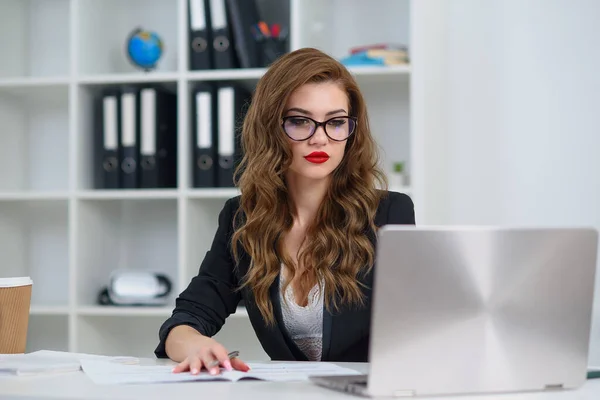 穿着正式服装的成功的女商人坐在舒适明亮的办公室里，与笔记本电脑一起工作。有经验的公司经理概念. — 图库照片