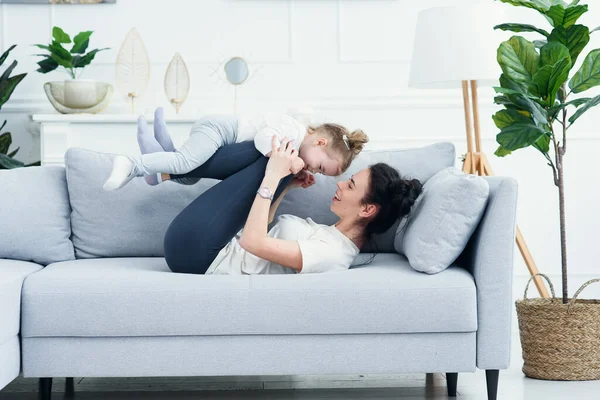 Mãe e sua filha deitada no sofá na sala de estar . — Fotografia de Stock