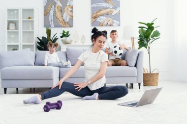 Anne kızıyla meditasyon yaparken enerjik bir çocuk oyun oynuyor, anne evde yoga egzersizi yapıyor ve küçük yaramaz çocukla stres atağı yapıyor. 4k video görüntüsü yavaş çekim