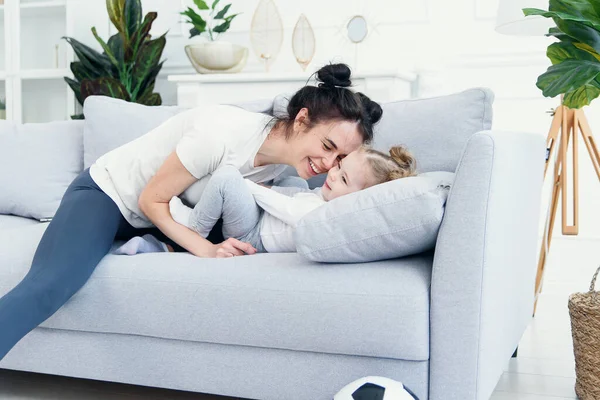 Mom and her daughter lying on the couch in the living room. — Stock Photo, Image