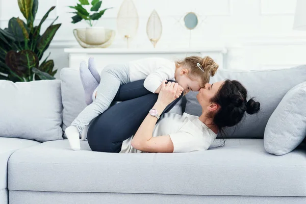 Mãe e sua filha deitada no sofá na sala de estar . — Fotografia de Stock