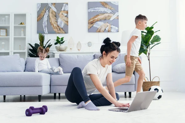 Mãe feliz no chão em casa com crianças e assistir desenhos animados engraçados no laptop. — Fotografia de Stock