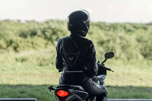 Lviv, Ukrayna - 01.07.2020: Siyah koruyucu giysili siyah Honda motosikletli bir kız. — Stok fotoğraf