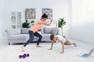 Spor anne ve oğlu sabah antrenmanı yapıyor. Anne ve oğul birlikte egzersiz yapıyor, sağlıklı aile hayatı konsepti.