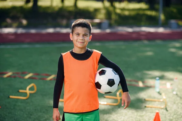 夏天，穿着足球制服的英俊疲惫的男孩在城市绿园的体育场接受训练后，身穿球衣. — 图库照片