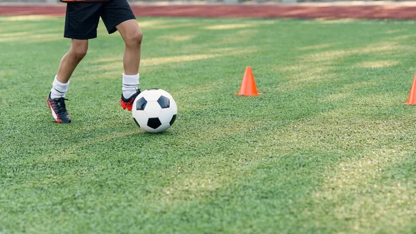 Giocatore di calcio che calcia palla sul campo. Giocatori di calcio in allenamento. Close up piedi calciatore calci palla sull'erba. — Foto Stock