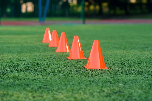 人工サッカーやサッカーの緑のフィールド上の5オレンジのトレーニングコーン,トレーニングスポーツ機器. — ストック写真