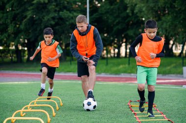 Futbol yaz kampı sırasında iki okul çocuğu sahada merdiven talimi yapıyor. Koçla yoğun futbol antrenmanı..