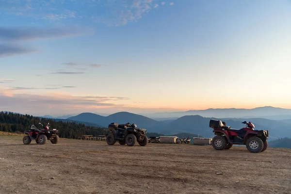 ATV Quad Kerékpárok a hegytetőn naplemente táj háttér. — Stock Fotó