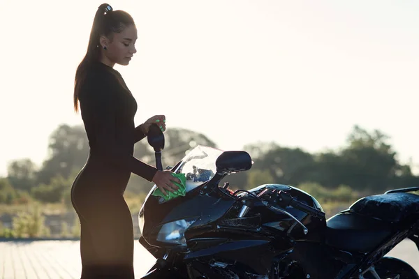 Jovem sedutora lavando motocicleta esportiva elegante e limpa da espuma roxa. Cuidados com o veículo. — Fotografia de Stock