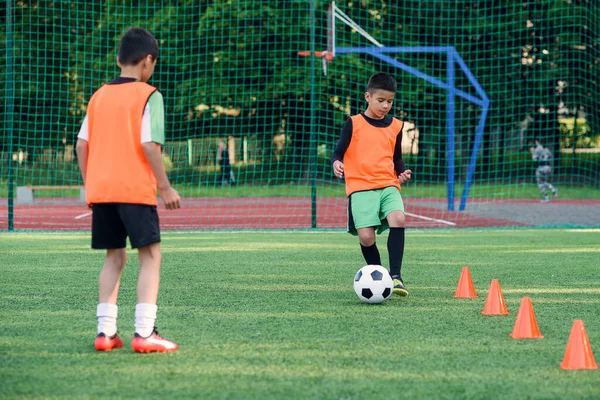 Deux adolescents passent le ballon de foot sur le stade de football. Travail d'équipe et concept de formation conjointe. — Photo