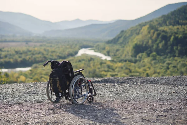 Порожній інвалідний візок на горах на заході сонця. Концепція подорожей людей з інвалідністю . — стокове фото