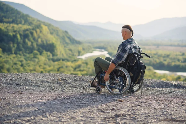 Спортсмен після травми в інвалідному візку насолоджується свіжим повітрям у горах. Реабілітація людей з інвалідністю . — стокове фото