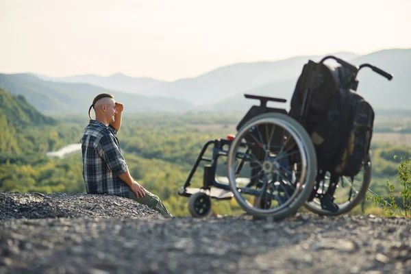Спортсмен після травми в інвалідному візку насолоджується свіжим повітрям у горах. Природна терапія людей з обмеженими можливостями . — стокове фото
