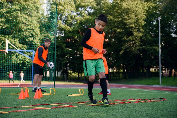 Giocatori di calcio per bambini durante l'allenamento di squadra prima di una partita importante. Esercizi per la squadra di calcio giovanile. — Foto Stock