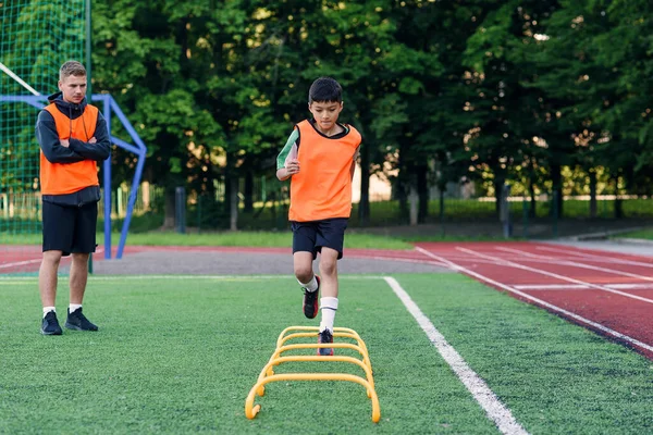 Kinderen voetbalspelers tijdens teamtraining voor een belangrijke wedstrijd. Oefeningen voor het jeugdvoetbalteam. — Stockfoto