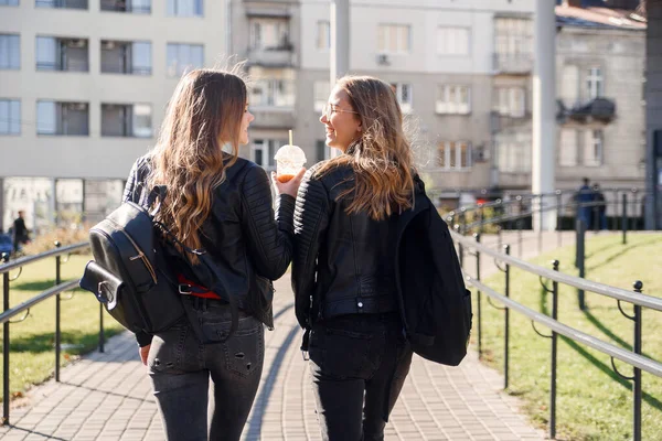 Sırt çantalı, sokakta yürüyen genç ve güzel kız arkadaşların arka görüntüsü.. — Stok fotoğraf