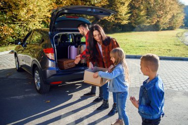 Cana yakın ebeveynler yeni daireye taşınırken 10-12 yaşlarında şirin çocuklarıyla birlikte bagajlarını boşaltıyor..